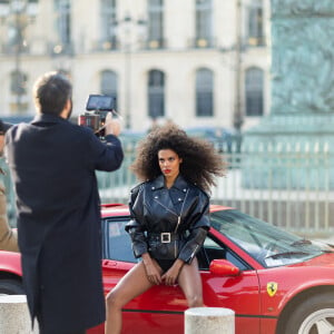 Exclusif - Le mannequin français Tina Kunakey en body et perfecto adossé à une Ferrari 308 lors d'un shooting photo sur la place Vendôme en marge du prêt-à-porter automne-hiver 2023/2024 de la Fashion Week de Paris (PFW) , à Paris, France, le 2 mars 2023. © Da Silva-Perusseau/Bestimage 