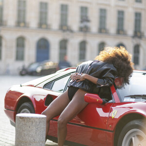 Exclusif -  Le mannequin français Tina Kunakey en body et perfecto adossé à une Ferrari 308 lors d'un shooting photo sur la place Vendôme en marge du prêt-à-porter automne-hiver 2023/2024 de la Fashion Week de Paris (PFW) , à Paris, France, le 2 mars 2023. © Da Silva-Perusseau/Bestimage 