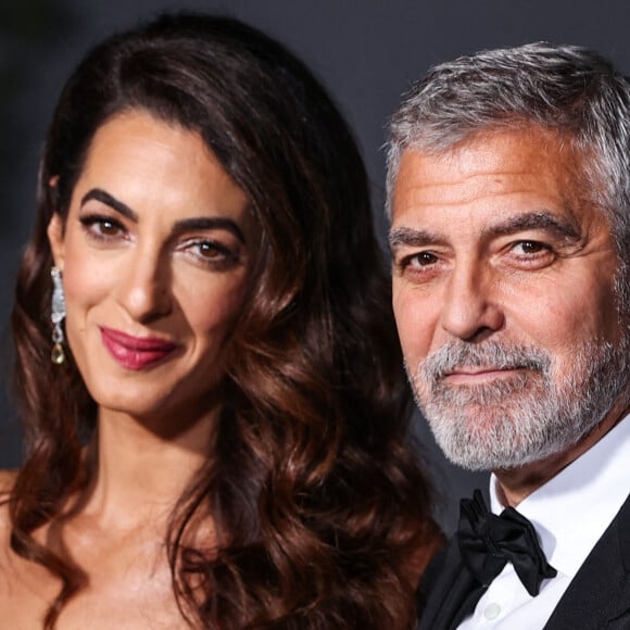 "Nous, nous avons du mal à survivre. Nous vendons des terres pour garder la tête hors de l'eau. Et au lieu de nous acheter nos légumes à nous, le maire préfère aller faire une ferme sur le terrain de George Clooney. Ça ressemble quand même à une opération de communication", poursuit-il.
Amal Alamuddin Clooney, George Clooney au photocall du "2nd Annual Academy Museum Gala" à Los Angeles, le 15 octobre 2022.