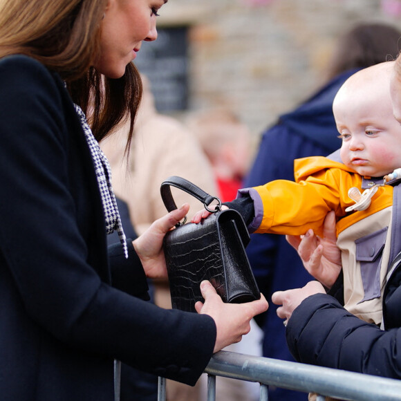 Dont un adorable bébé qui a volé le sac de Kate Middleton ! 
Le jeune Daniel Williams joue avec le sac à main de Catherine (Kate) Middleton, lors de sa visite au jardin commémoratif d'Aberfan, le 28 avril 2023.