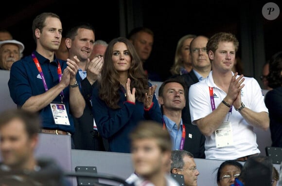 Le prince William et le prince Harry et Kate Middleton assistent à la finale d'athlétisme du 100 mètres aux Jeux Olympiques de Londres en 2012. 