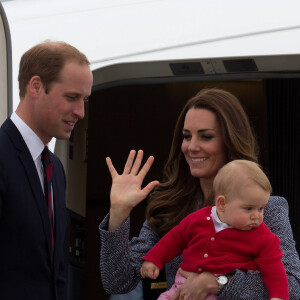 Le prince William, Catherine Kate Middleton la duchesse de Cambridge et leur fils George montent à bord d'un avion pour rentrer à Londres après leur visite officielle en Australie, le 25 avril 2014. 