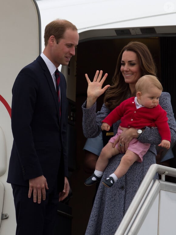 Le prince William, Catherine Kate Middleton la duchesse de Cambridge et leur fils George montent à bord d'un avion pour rentrer à Londres après leur visite officielle en Australie, le 25 avril 2014. 