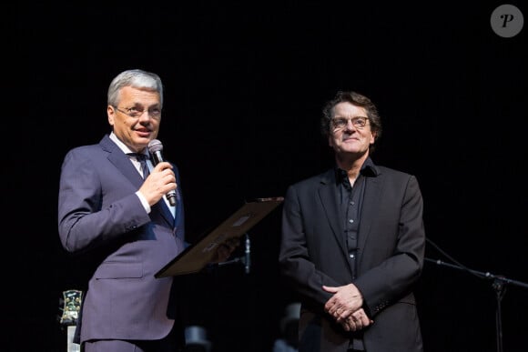Francis Cabrel reçoit la décoration d'officier de l'ordre de la Couronne par le vice-premier ministre et ministre des affaires étrangères Didier Reynders lors de son concert au Palais 12 à Bruxelles, le 15 avril 2014.