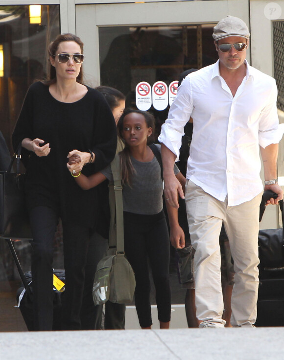 Il aurait notamment "essayé d'étouffer" l'un d'entre eux !
Angelina Jolie et Brad Pitt arrivent à l'aéroport de Los Angeles avec leurs enfants Zahara et Maddox en provenance de Londres, le 14 juin 2014. 