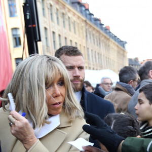 Brigitte Macron, Presidente de la Fondation des Hopitaux, signe des autographes aux enfants des ecoles lilloises. Pesée de toute la monnaie récoltée dans les fameuses tirelires pour clôturer de l'Opération Pièces Jaunes 2023 sur la place du théâtre à Lille, France, ce vendredi 3 février 2023 après presque un mois de collecte national. L'événement a commencé à 14h et un point presse en présence des représentants de la Fondation des Hôpitaux et de la Mairie de Lille aura lieu à 15h sous la forme d'un micro-tendu. Sur place, vous pourrez suivre les différentes animations, parmi lesquelles la pesée des pièces récoltées pendant l'opération, des séances photos devant les tirelires géantes, des animations d'associations lilloises et des concerts d'artistes nationaux. © Claude Dubourg/Bestimage 