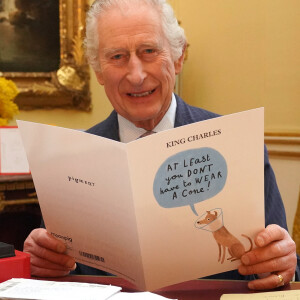 Le roi Charles III d'Angleterre, lit les messages reçus à Buckingham Palace à Londres, après le diagnostic sur son cancer, le 23 février 2024. 