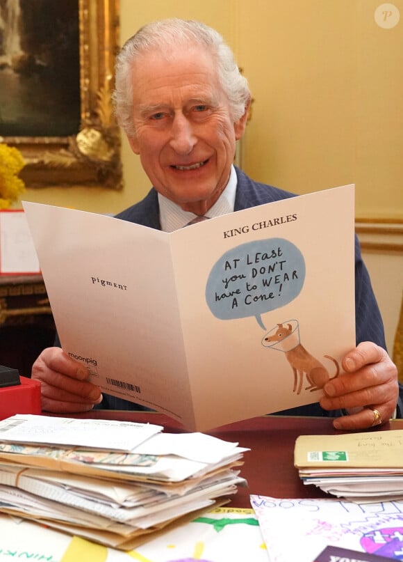Le roi Charles III d'Angleterre, lit les messages reçus à Buckingham Palace à Londres, après le diagnostic sur son cancer, le 23 février 2024. 