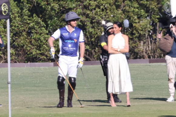 Palm Beach, FL - Meghan Markle, en robe blanche et talons hauts, arrive main dans la main avec le prince Harry au Royal Salute Polo Challenge à Miami. Le couple heureux était entouré d'une équipe de tournage de la nouvelle émission Netflix de Duke sur ce sport élitiste.