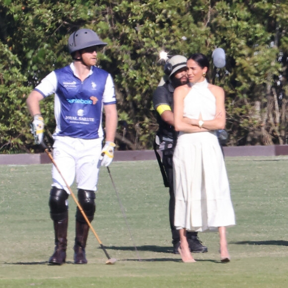 Palm Beach, FL - Meghan Markle, en robe blanche et talons hauts, arrive main dans la main avec le prince Harry au Royal Salute Polo Challenge à Miami. Le couple heureux était entouré d'une équipe de tournage de la nouvelle émission Netflix de Duke sur ce sport élitiste.