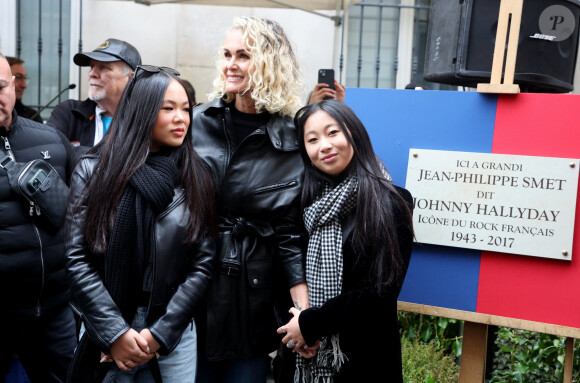 Laeticia Hallyday, ses filles Joy et Jade lors de l'inauguration d'une plaque commémorative en hommage à Johnny Hallyday devant l'immeuble où le chanteur français a grandi dans le 9ème arrondissement de Paris, France, le 22 décembre 2023. Décédé en 2017, Johnny Hallyday fut pendant un demi-siècle l'incarnation du rock à la française. D'origine belge et né sous le nom de Jean-Philippe Smet, il naquit et passa une très grande partie de sa vie à Paris. Fière de cet héritage musical qu'il lui laissa, la Ville de Paris avait entrepris un premier hommage à l'artiste en donnant le nom de Johnny Hallyday à l'esplanade situé devant la salle de spectacle qu'il avait tant fait vibrer par le passé. Dans la continuité de ce premier hommage, la ville de Paris a souhaité à nouveau honorer la mémoire de ce natif de la capitale et une plaque commémorative est dévoilée devant l'immeuble dans lequel il grandit au 13 rue de la Tour des Dames dans le 9ème arrondissement. © Dominique Jacovides/Bestimage