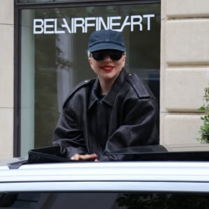Lady Gaga salue ses fans en sortant par le toit ouvrant de sa voiture dans les rues de Paris, le 22 juillet 2024