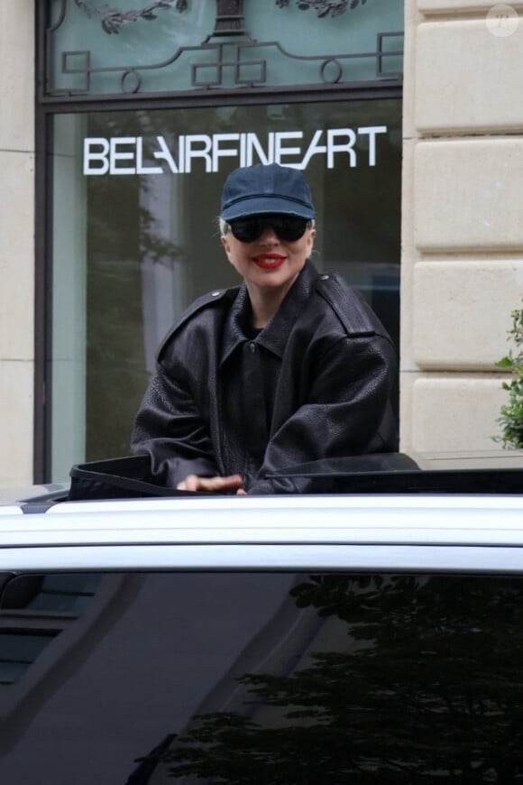 Lady Gaga salue ses fans en sortant par le toit ouvrant de sa voiture dans les rues de Paris, le 22 juillet 2024