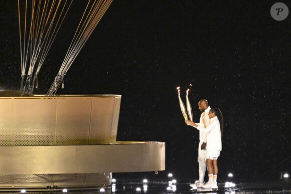 Teddy Riner et Marie-José Pérec les derniers relayeurs de la flamme Olympiques au chaudron attaché à un ballon géant lors de la cérémonie d'ouverture des Jeux Olympiques (JO) de Paris 2024, à Paris, France, le 26 juillet 2024. © Michael Baucher /Panoramic/Bestimage 