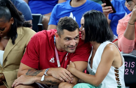 Petits mots murmurés à l'oreille, gestes d'affection, regards tendres… Florent avait de quoi être déconcentré ! 
Florent Manaudou et sa compagne Lola Duménil - Les célébrités assistent à la victoire de l'équipe de France de basket face au Canada (82-73) lors des Jeux Olympiques de Paris2024, le 6 août 2024. © Jacovides-Perusseau / Bestimage