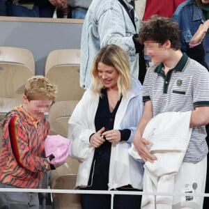 Roman et Aliocha Haroche voient Carlos Alcaraz dédicacer leurs casquettes sous le regard de leurs parents, Mélanie Thierry et son compagnon Raphaël dans les tribunes des Internationaux de France de tennis de Roland Garros 2024 à Paris, le 29 mai 2024. © Jacovides / Moreau / Bestimage 