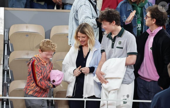 Roman et Aliocha Haroche voient Carlos Alcaraz dédicacer leurs casquettes sous le regard de leurs parents, Mélanie Thierry et son compagnon Raphaël dans les tribunes des Internationaux de France de tennis de Roland Garros 2024 à Paris, le 29 mai 2024. © Jacovides / Moreau / Bestimage 