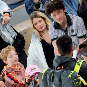 Roman et Aliocha Haroche voient Carlos Alcaraz dédicacer leurs casquettes sous le regard de leurs parents, Mélanie Thierry et son compagnon Raphaël dans les tribunes des Internationaux de France de tennis de Roland Garros 2024 à Paris, le 29 mai 2024. © Jacovides / Moreau / Bestimage 