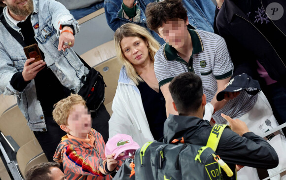 Roman et Aliocha Haroche voient Carlos Alcaraz dédicacer leurs casquettes sous le regard de leurs parents, Mélanie Thierry et son compagnon Raphaël dans les tribunes des Internationaux de France de tennis de Roland Garros 2024 à Paris, le 29 mai 2024. © Jacovides / Moreau / Bestimage 