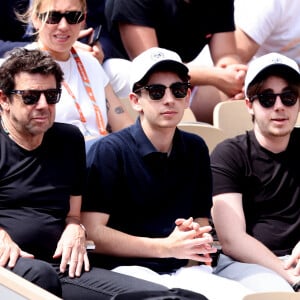 Patrick Bruel et ses fils Léon et Oscar dans les tribunes des Internationaux de France de tennis de Roland Garros 2024 à Paris, France, le 4 juin 2024. © Jacovides-Moreau/Bestimage 