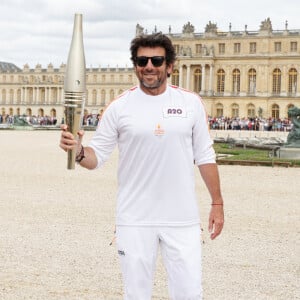 Le chanteur et acteur Patrick Bruel porteur de la flamme olympique des Jeux Olympiques de Paris 2024 (JO) au château de Versailles dans les Yvelines, France, le 23 juillet 2024. © Dominique Jacovides/Bestimage 