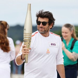 Le chanteur et acteur Patrick Bruel porteur de la flamme olympique des Jeux Olympiques de Paris 2024 (JO) au château de Versailles dans les Yvelines, France, le 23 juillet 2024. © Dominique Jacovides/Bestimage 