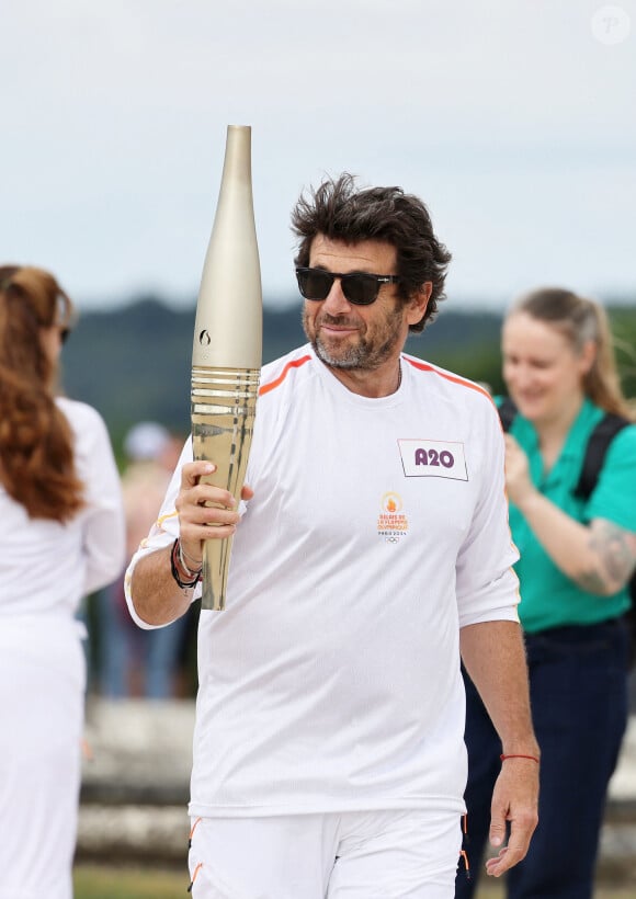 Le chanteur et acteur Patrick Bruel porteur de la flamme olympique des Jeux Olympiques de Paris 2024 (JO) au château de Versailles dans les Yvelines, France, le 23 juillet 2024. © Dominique Jacovides/Bestimage 