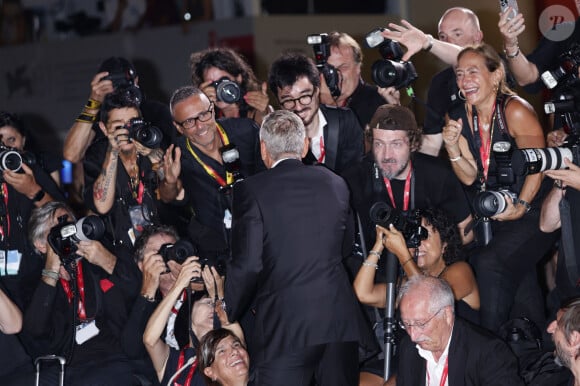 George Clooney a ensuite pris la pose au milieu des photographes pour immortaliser ce moment qui risque de rester gravé dans la mémoire de certains. 
George Clooney avec les photographes à la projection de "Wolfs" lors du 81ème festival international du film de Venise, la Mostra le 1er septembre 2024.