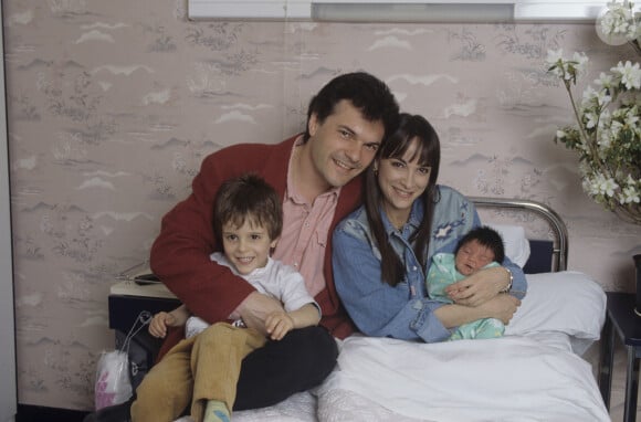 Ariane Carletti tenant dans ses bras sa fille Éléonore, dans sa chambre de la maternité avec à ses côtés son mari Rémy Sarrazin, son fils Tristan le 31 mars 1994