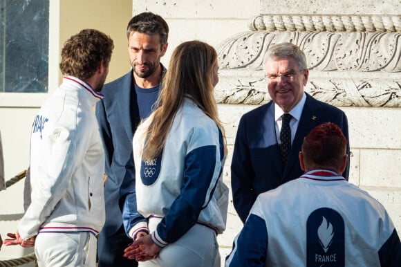 Tony Estanguet, president du COJO et Thomas Bach, president du CIO, echange avec des athletes olympiques, lors du ravivage de la flamme du soldat inconnu, a l Arc de triomphe. © Eric Tschaen/Pool/Bestimage 