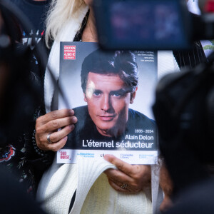 Les fans rendent hommage à Alain Delon devant la grille de sa propriété à Douchy-Montcorbon pendant ses obsèques le 24 août 2024. © Baptiste Autissier / Panoramic / Bestimage