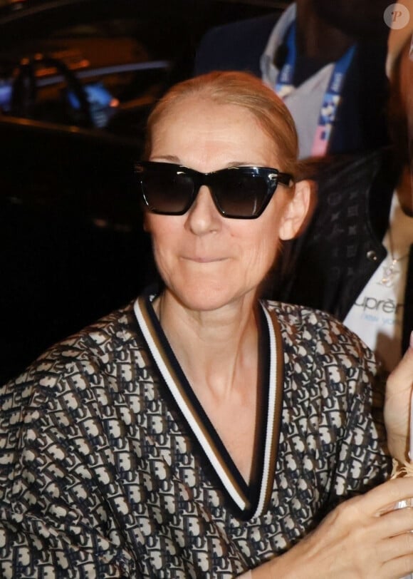 Céline Dion salue une foule de fans alors qu'elle sort de son hôtel avec son fils RC Angelil à Paris, France