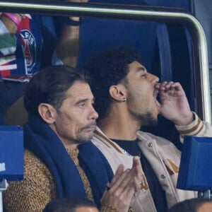 Kool Shen (Bruno Lopes) et son fils Giani Lopes dans les tribunes lors du match de Ligue Des Champions (LDC) "PSG - PSV Eindhoven (1-1)" au Parc des Princes à Paris, le 22 octobre 2024.