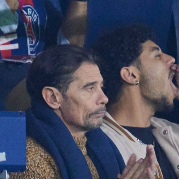 Kool Shen (Bruno Lopes) et son fils Giani Lopes dans les tribunes lors du match de Ligue Des Champions (LDC) "PSG - PSV Eindhoven (1-1)" au Parc des Princes à Paris, le 22 octobre 2024.