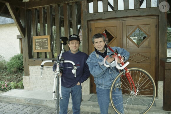 En France, en Normandie, en exterieur, lors du tournage de l'émission Ciné Stars, a Deauville, Michel Drucker, portant une casquette et Claude Lelouch chacun une bicyclette sur l'épaule. © Bruno Schneider via Bestimage