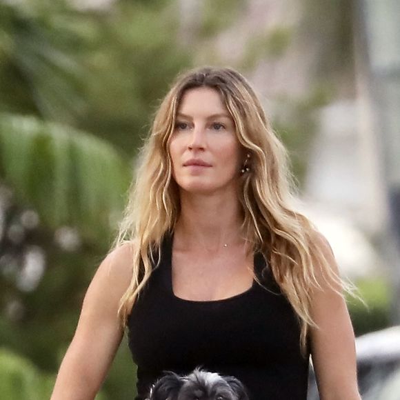 EXCLUSIF : Gisele Bundchen a été aperçue en train de promener ses chiens à Miami Beach, en Floride. Le top model brésilien portait un débardeur noir, un legging assorti et des sandales. Gisele portait un adorable petit chiot tandis que son berger allemand restait près d'elle.