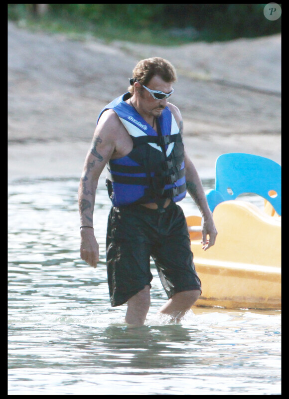Johnny Hallyday sort de l'eau après une virée en scooter des mers. Août 2010