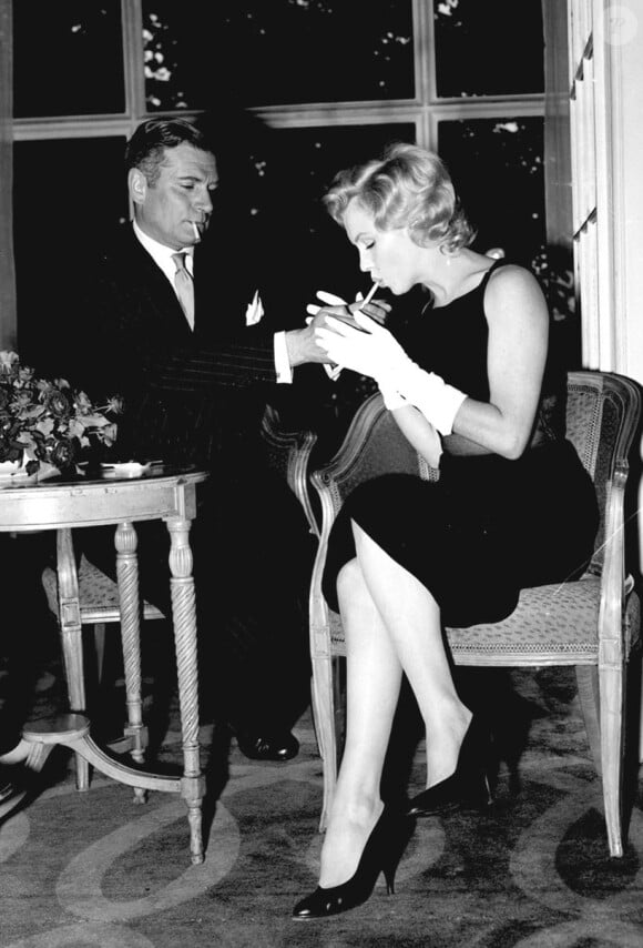 Laurence Olivier allume la cigarette de l'actrice Marilyn Monroe avec qui il joue et qu'il dirige dans Le Prince et la danseuse en 1956