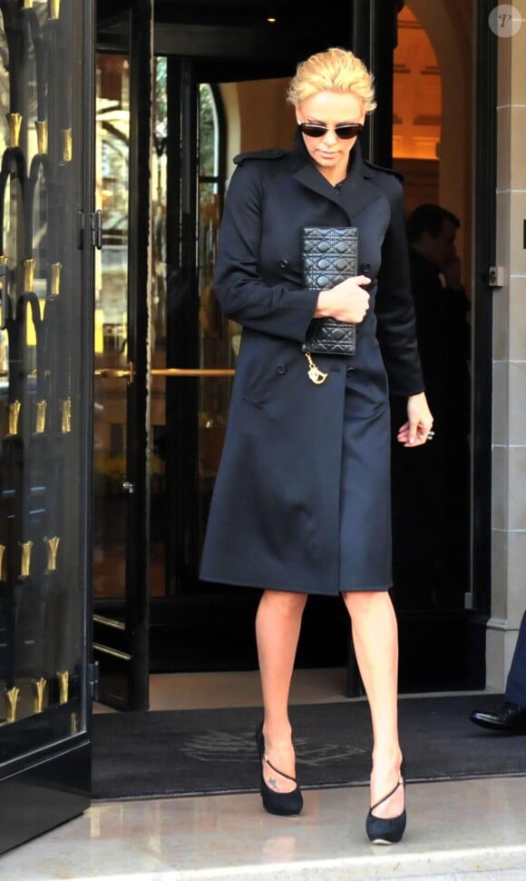Charlize Theron à la sortie de son hôtel parisien avec un trench Burberry noir.