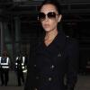 Victoria Beckham mise pour un look sûr en manteau Burberry, lunettes oversize et bottines noires. 