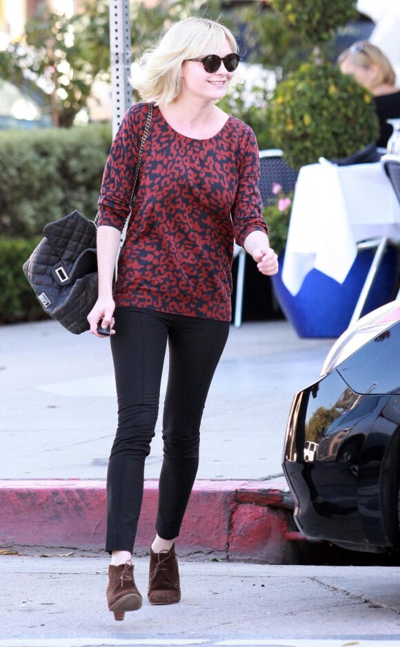 Kirsten Dunst sait jouer avec les it-pièces. Sweat shirt animalier mais rouge, slim noir, bottines en daim et le must : un 2.55 de Chanel. Parfait !