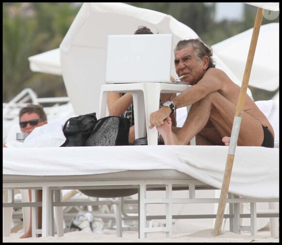 Roberto Cavalli et une amie sur une plage de Miami, le 20 novembre 2010