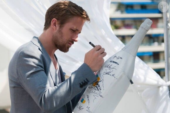 Ryan Gosling sur la terrace Nikki Beach à Cannes le 20 mai 2011, signant le Mathusalem de Maison Vendôme qui sera vendu aux enchères par la Fondation Quintessentially