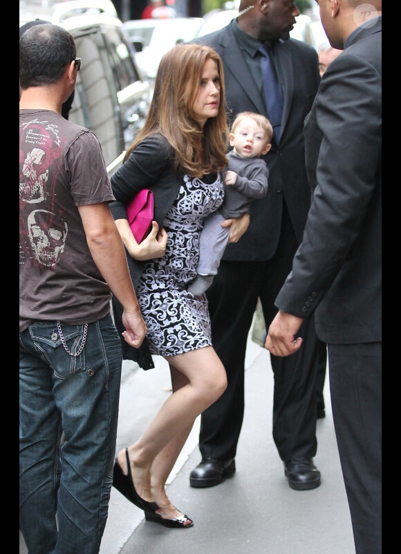 Kelly Preston porte son petit Benjamin alors qu'elle s'apprête à entrer dans le restaurant Dave à Paris le 20 juin 2011