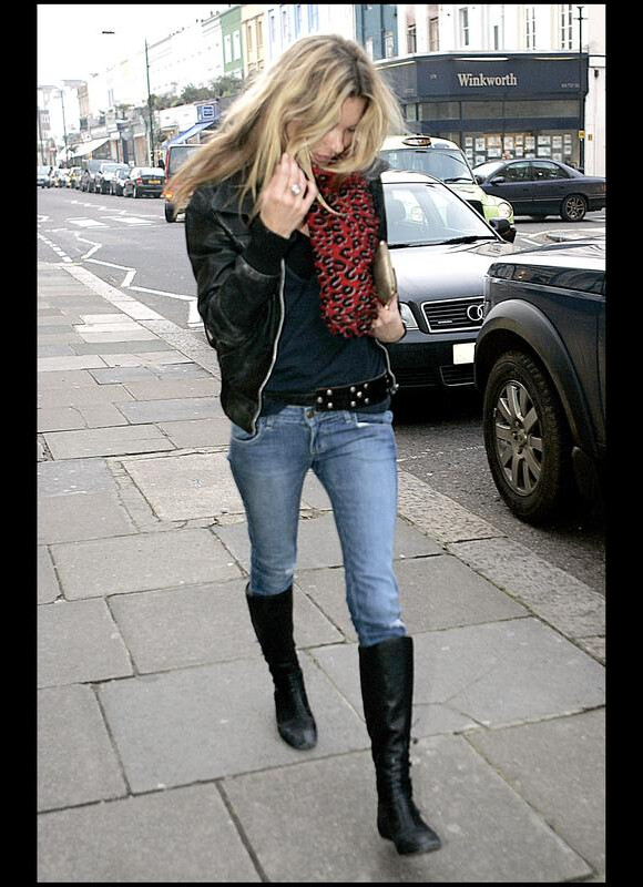 Kate Moss fait une fois de plus dans la simplicité côté look. Veste en cuir, slim bleu, bottes et foulard rouge aux imprimés léopard Louis Vuitton. A Londres, le 20 décembre 2006.
