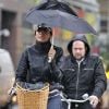 Famke Janssen à vélo, mais avec un parapluie