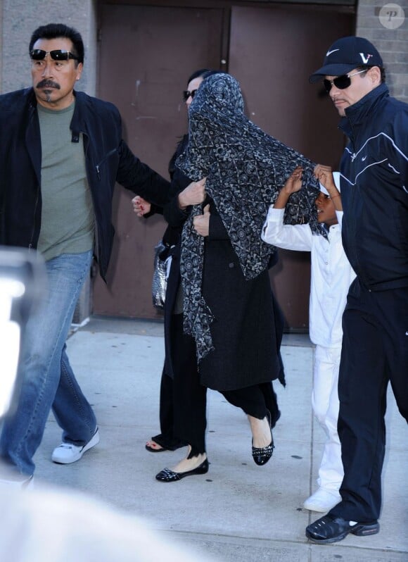 Madonna, camouflée sous un châle, sort du Centre de la Kabbale à New York le 8 octobre 2011, en compagnie de son fils David