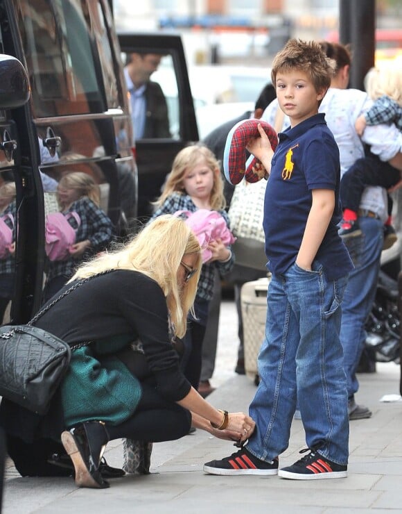Mère au petit soin, Claudia Schiffer refait le lacet de son fils Caspar (8 ans). Londres, le 18 octobre 2011.
