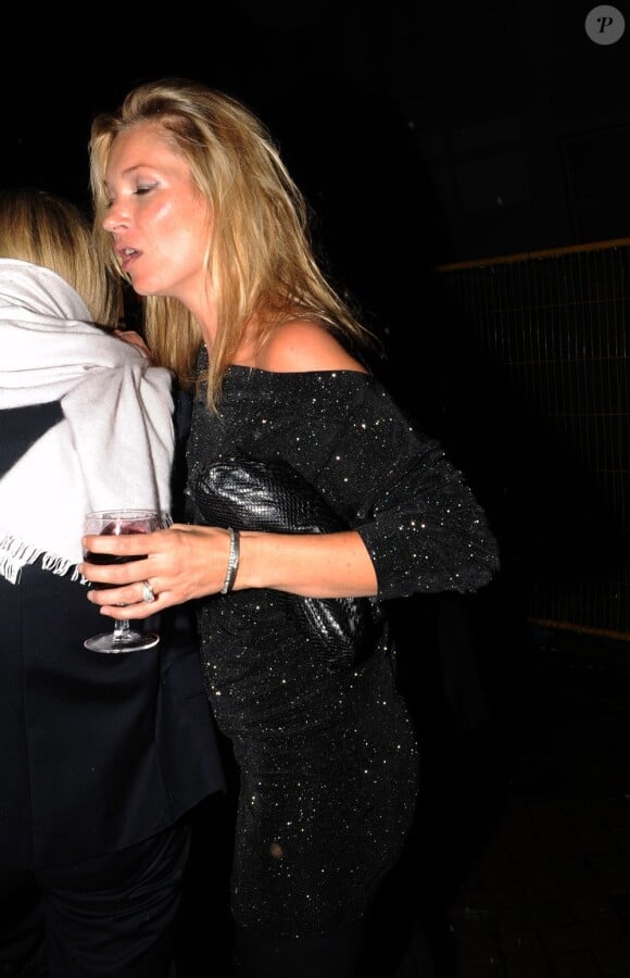 Kate Moss la bouche entrouverte sort du restaurant St John's avec un verre de vin rouge à la main, à Londres le 3 novembre 2011