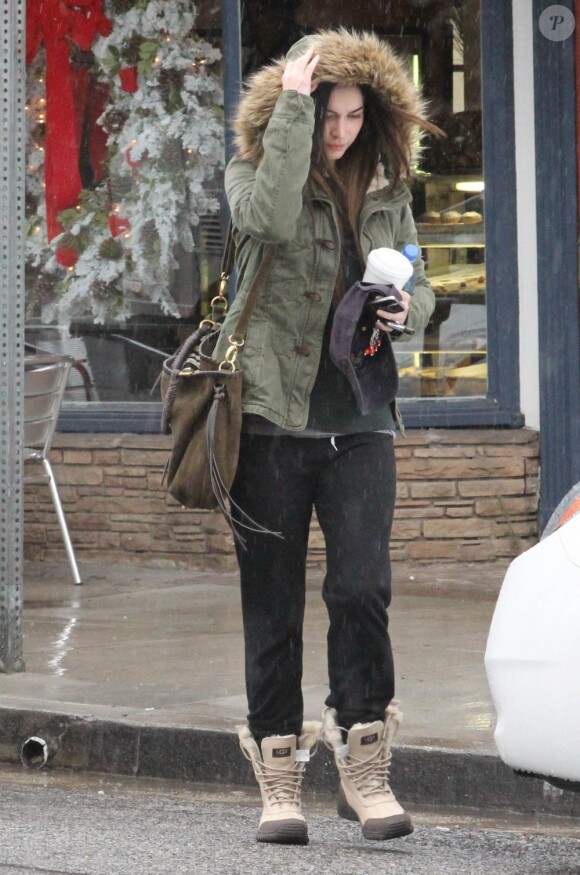 Pour protéger son brushing, Megan Fox se cache de la pluie à Los Angeles le 12 décembre 2011